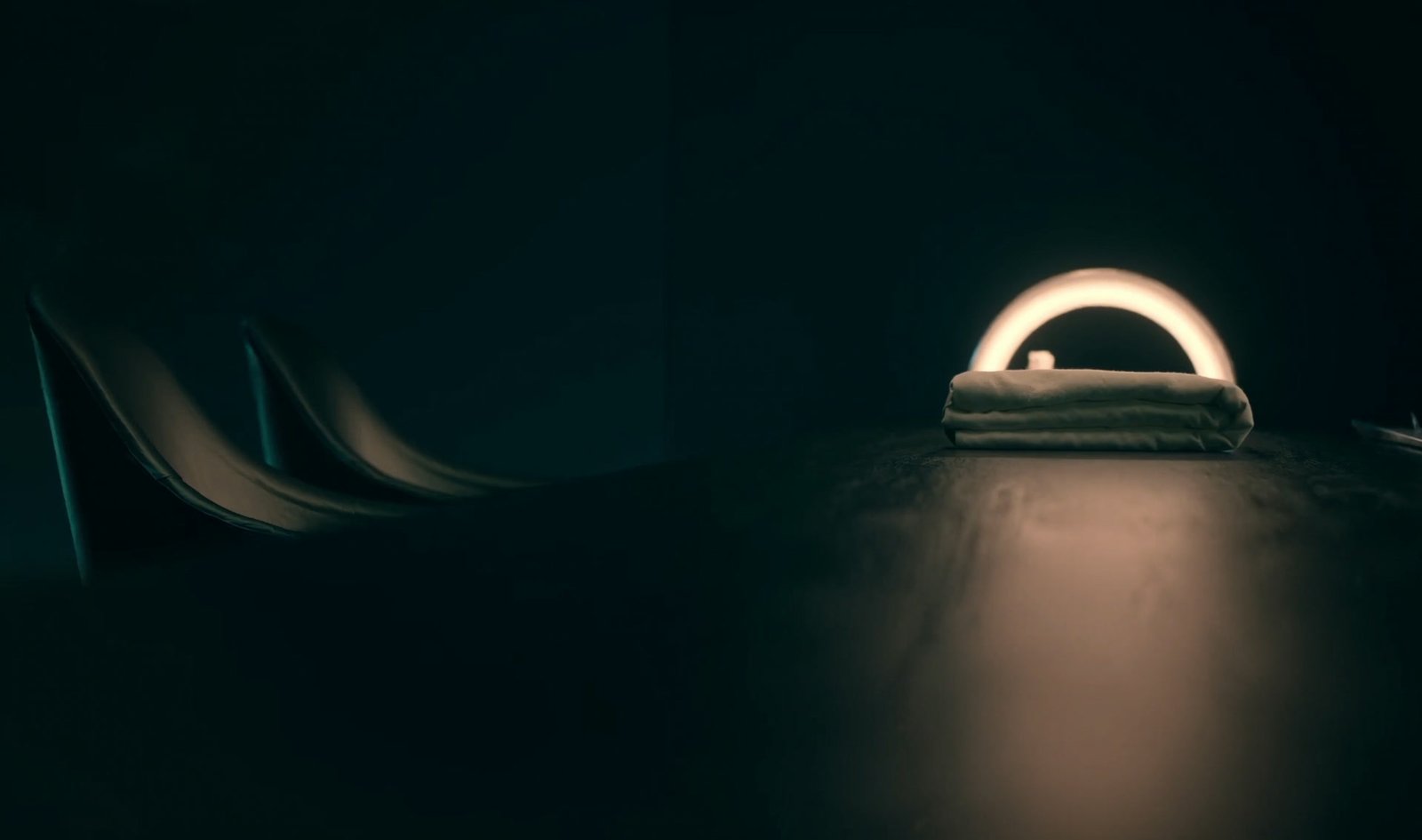 A folded towel under the glowing arch of a curing lamp